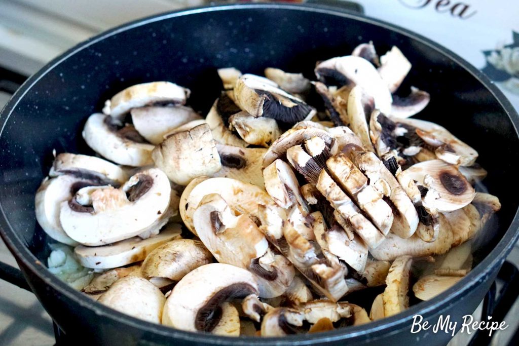 Adding sliced mushrooms to the pan to sautee for the mushroom sauce