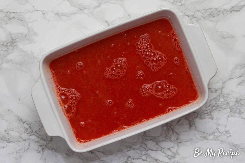 Watermelon juice in a white pan that will go in the freezer