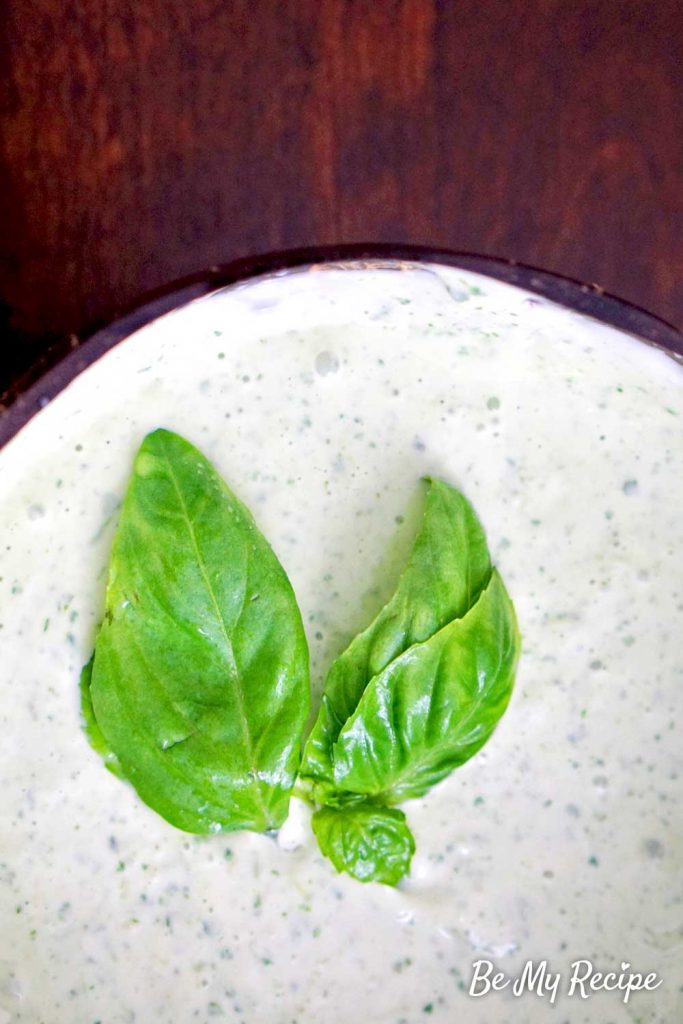 Lemon basil aioli sauce with fresh basil leaves (view from above).