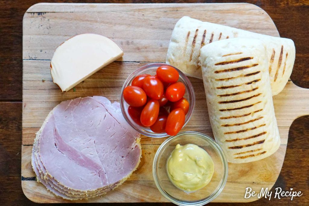 Ham and Cheese Panini Ingredients on a wooden board.