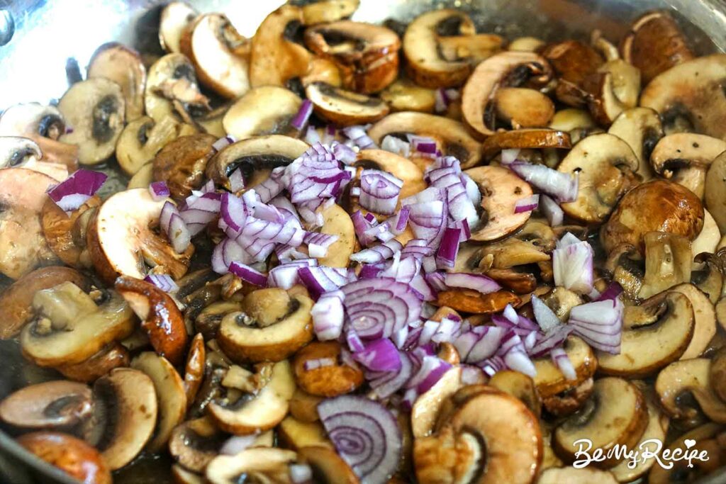 Adding onions and the seasoning to the mushrooms.
