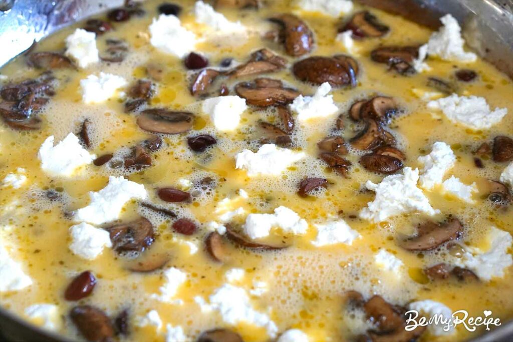 Adding the goat cheese to the frittata, and now ready to go into the oven.