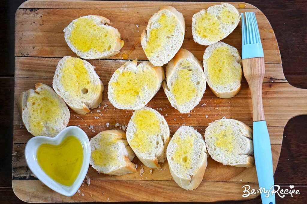Brushing the baguette slices with olive oil
