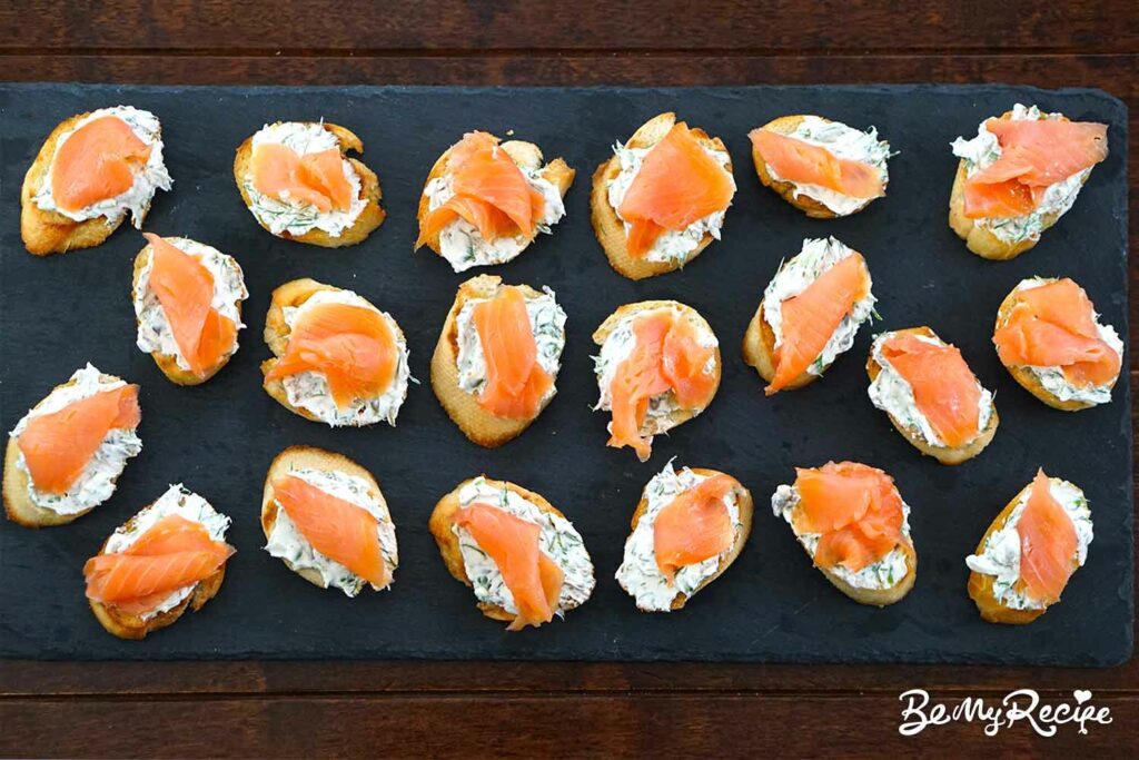 Topping the crostini with smoked salmon