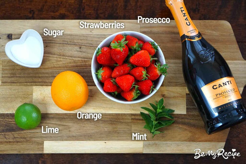 Strawberry Prosecco Sangria ingredients on a wooden board.