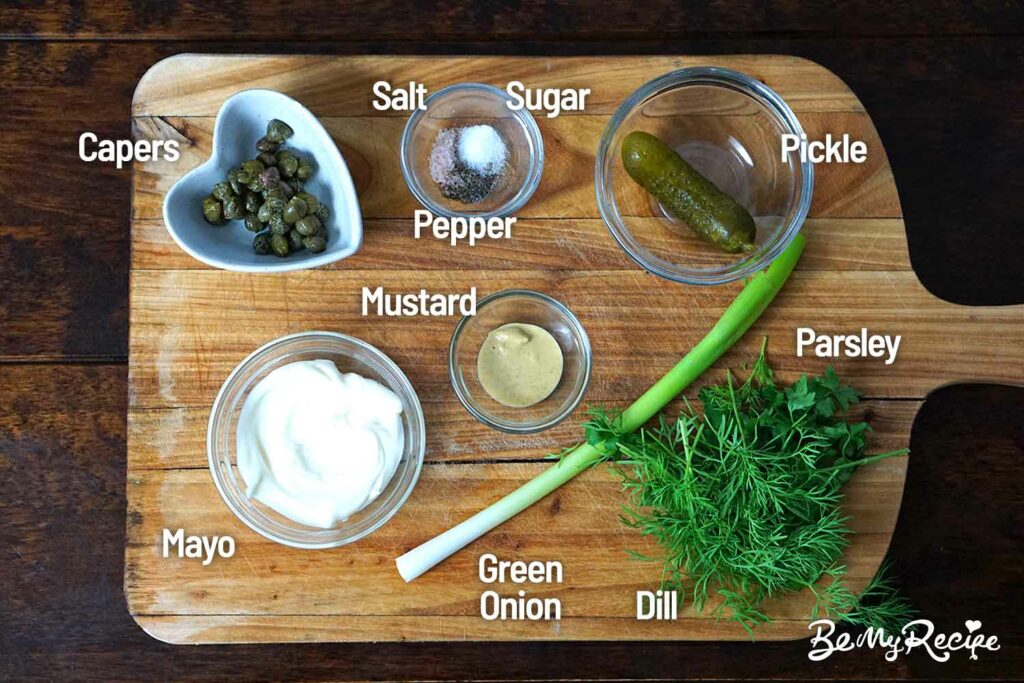 Salmon burger sauce ingredients on a wooden board.