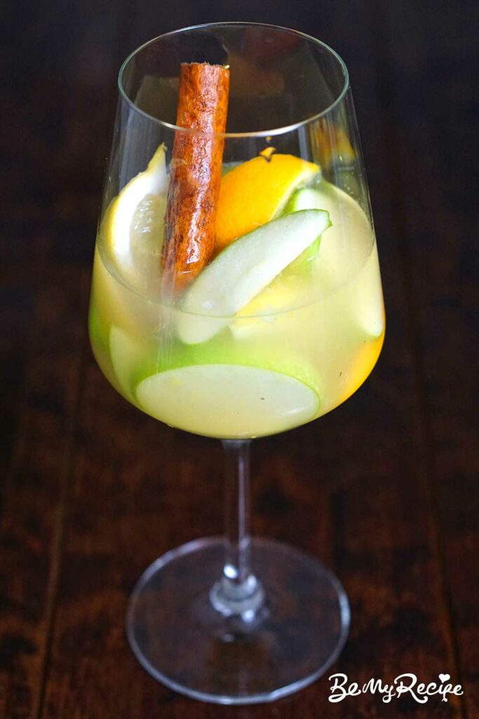 Apple Cider Sangria with Oranges, Lemons, and Cinnamon in a glass.