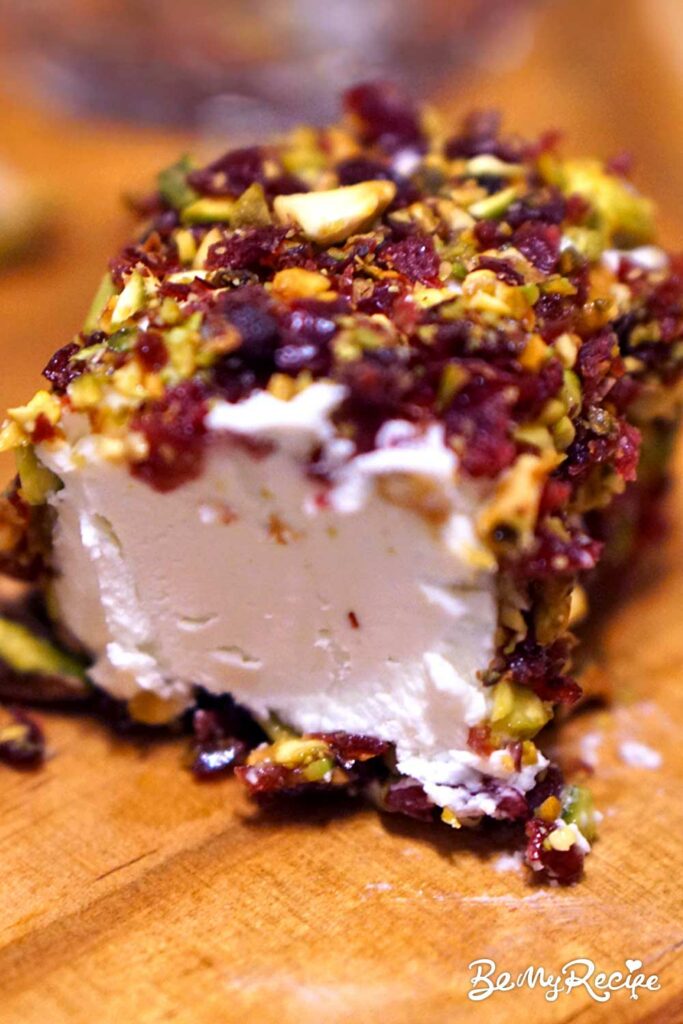 Goat cheese log covered in pistachios, cranberries, and honey