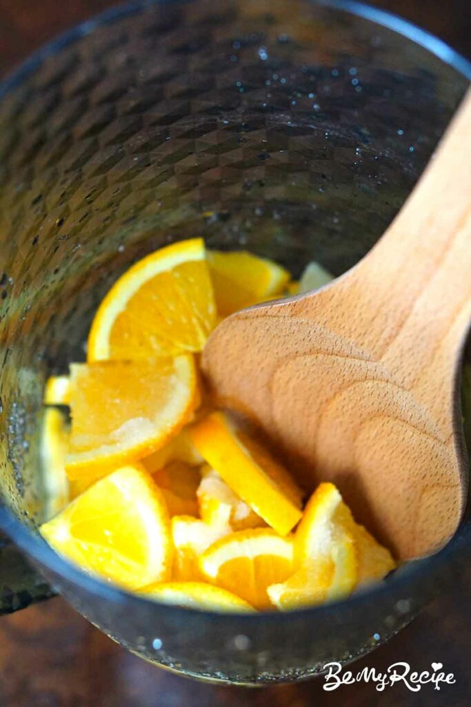 Muddling the citrus in a pitcher.