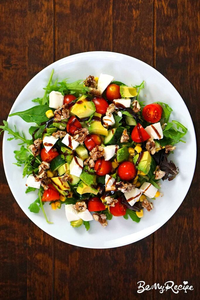 Salad with corn, tomatoes, avocado, and candied nuts