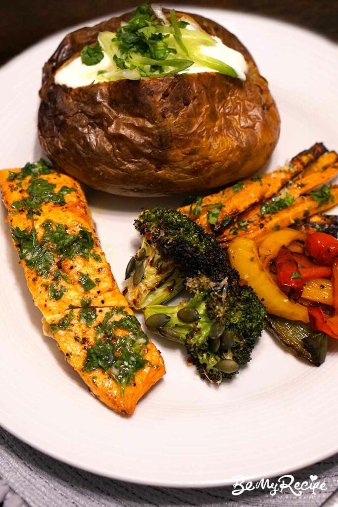 Air fryer salmon with garlic-lemon butter sauce with various sides (broccoli, peppers, carrot fries, baked potato).