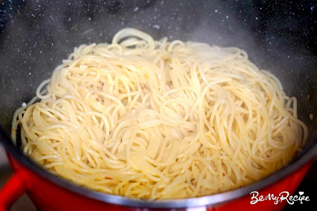 Adding the spaghetti to the butter chili garlic