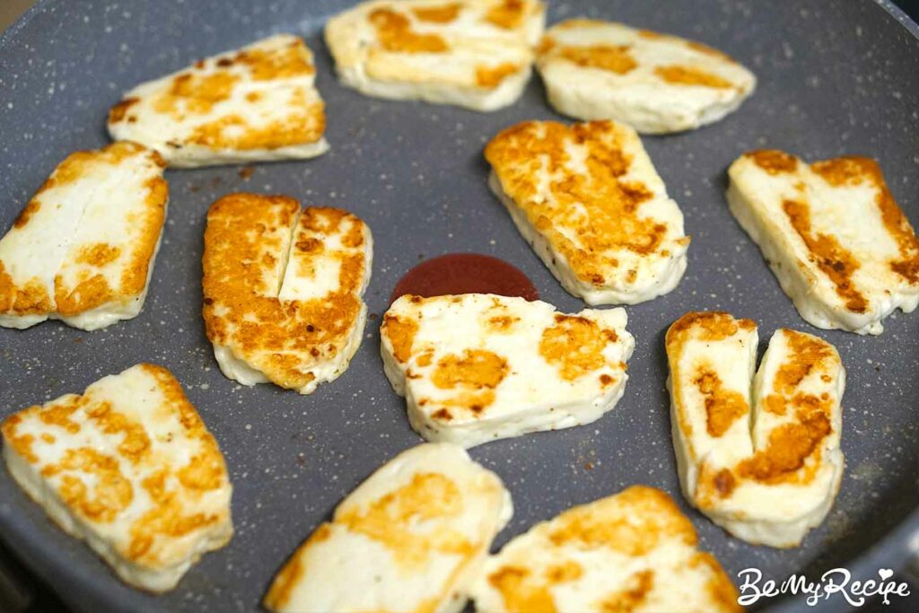 Golden halloumi slices in the frying pan