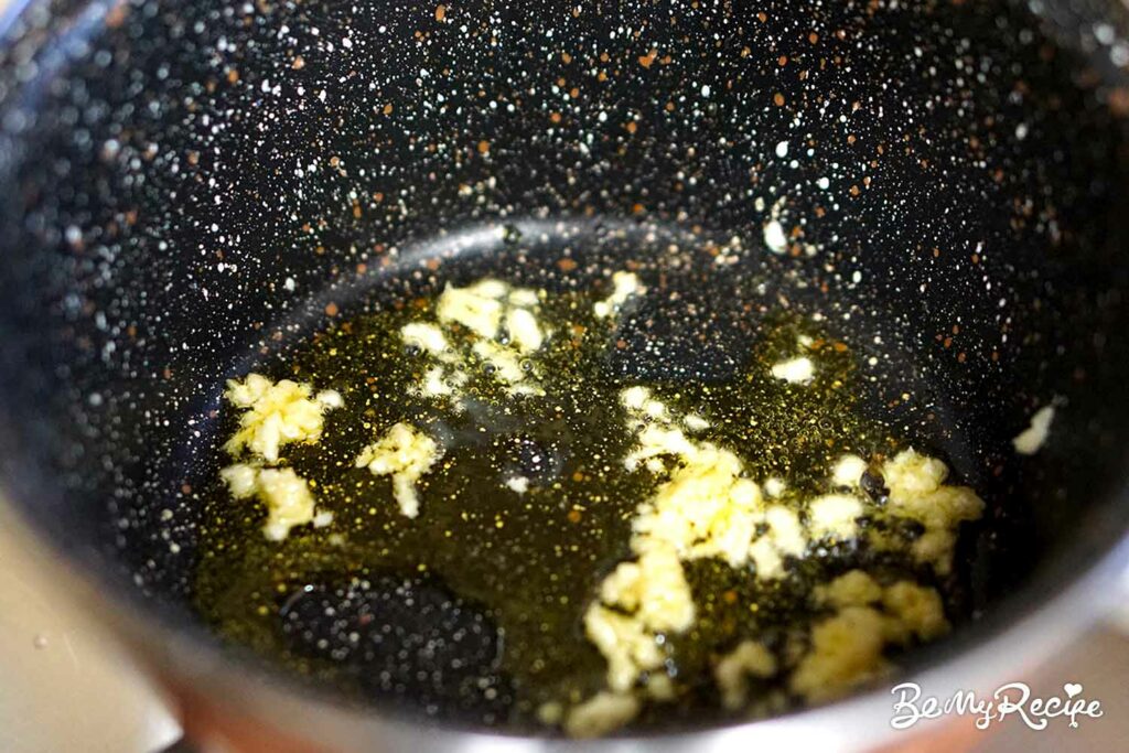 Sauteing the minced garlic in olive oil