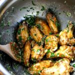 Air fryer chicken wings tossed in a garlic butter sauce with parmesan and parsley