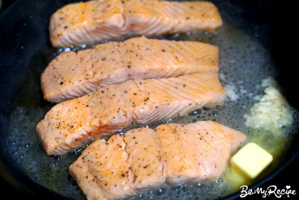pan-frying the salmon and adding the lemon, butter, and garlic