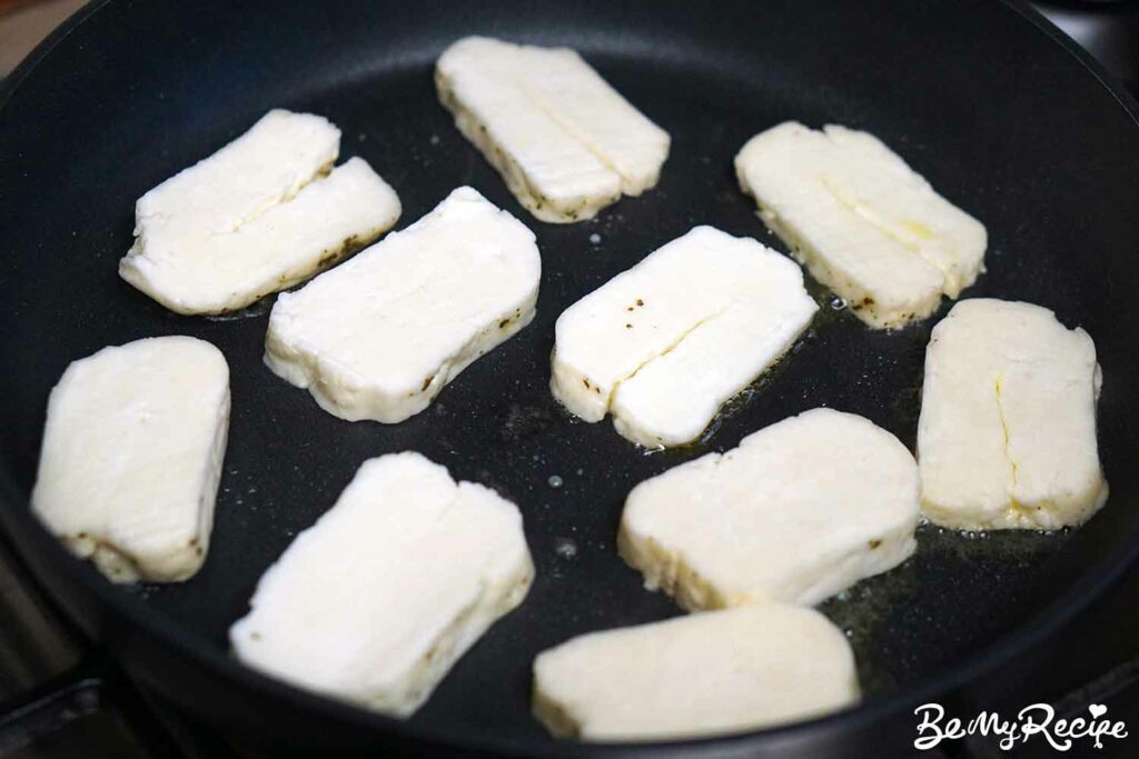 Pan-frying the halloumi slices.