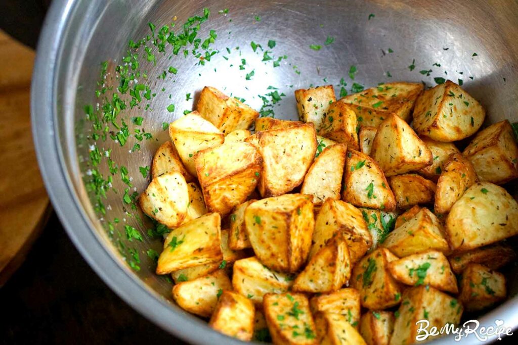 Tossing the potato bites with salt and parsley