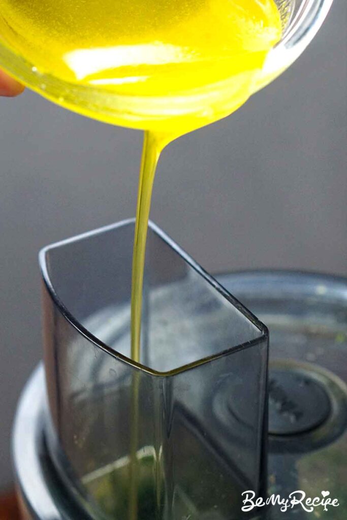 Adding the olive oil to make the pesto