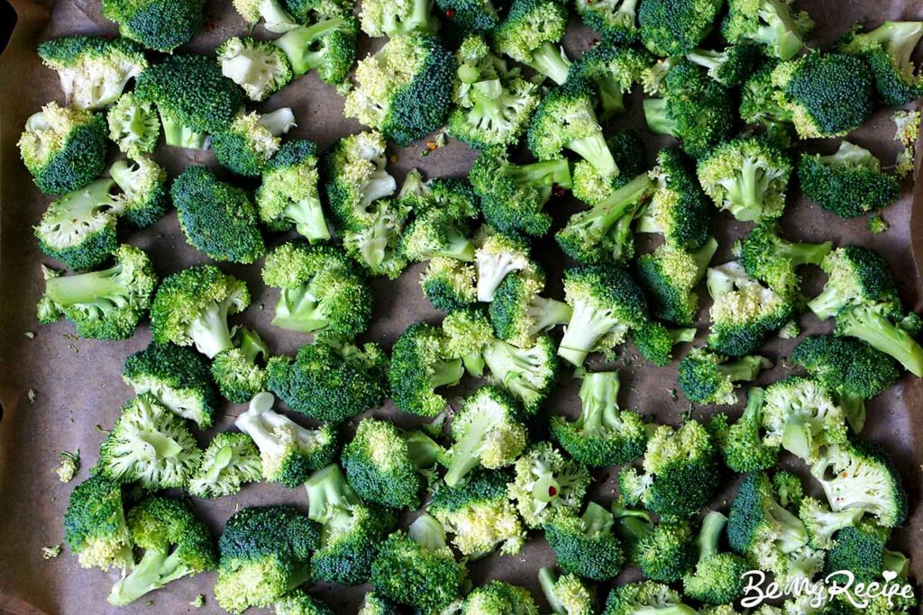 Chopped broccoli florets seasoned with salt, pepper, and red pepper flakes.